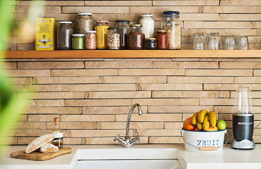 kitchen countertop with a sink in front of a wooden backsplash